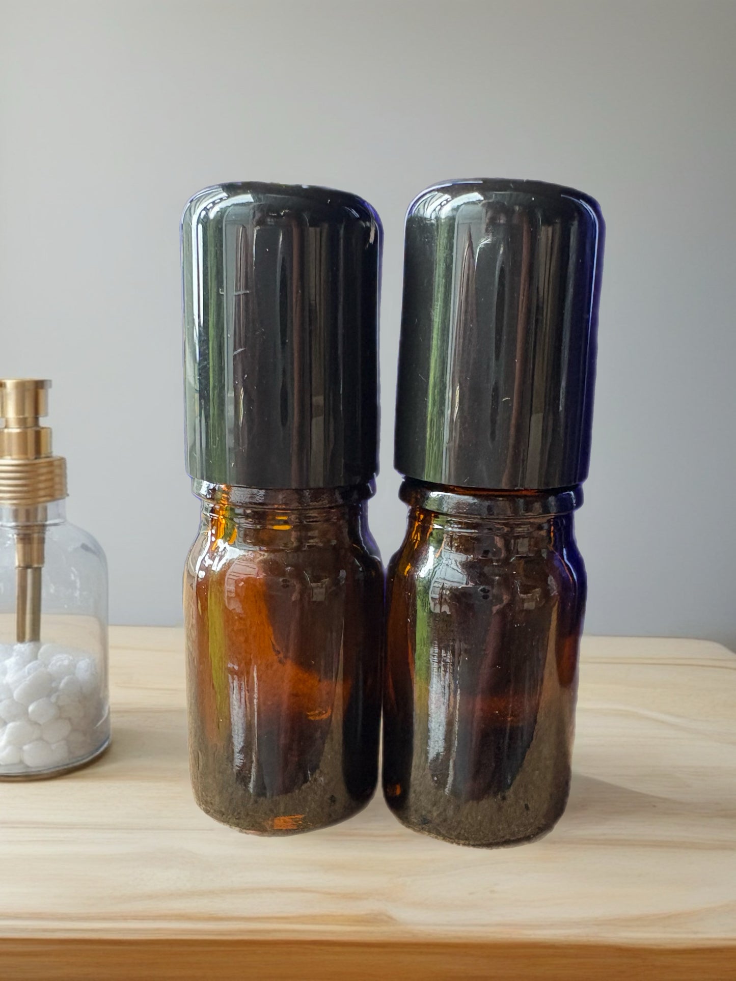 2 mL amber glass bottle with precision drip top and black lid.